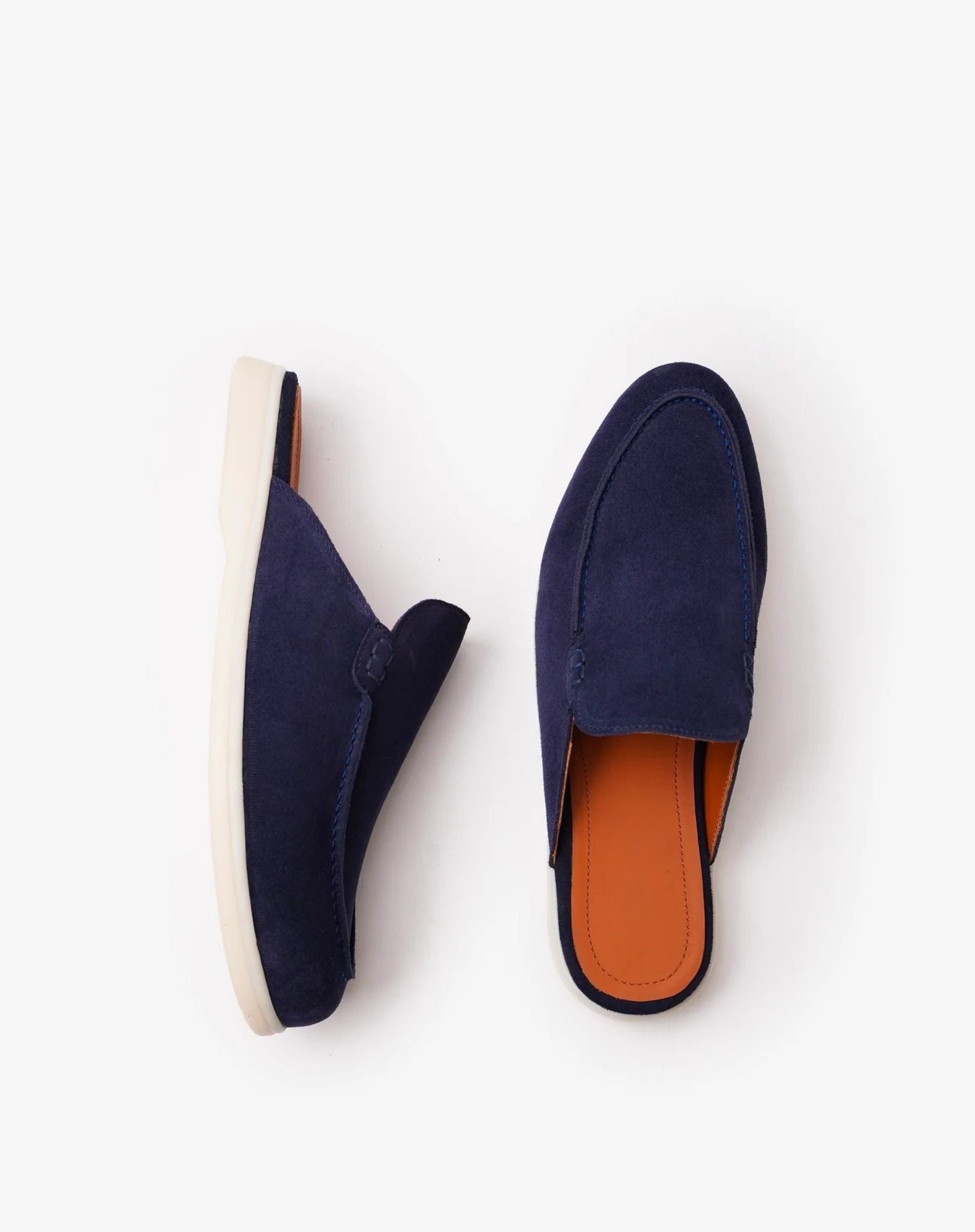 Pair of navy blue loafers with orange soles on a white background